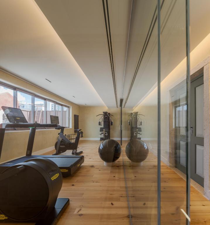 A compact glass-walled gym contains cardio equipment and a cable-training station.