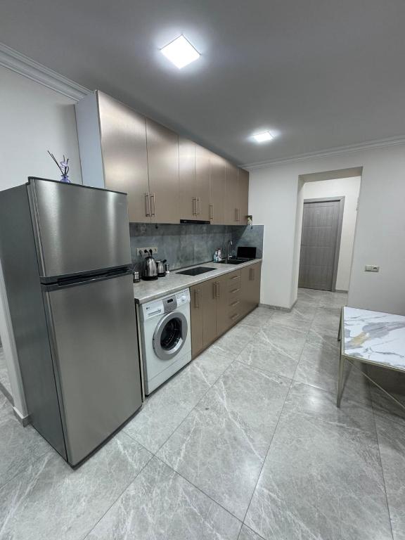 a kitchen with a stainless steel refrigerator and a dishwasher at Ava Hostel Yerevan in Yerevan