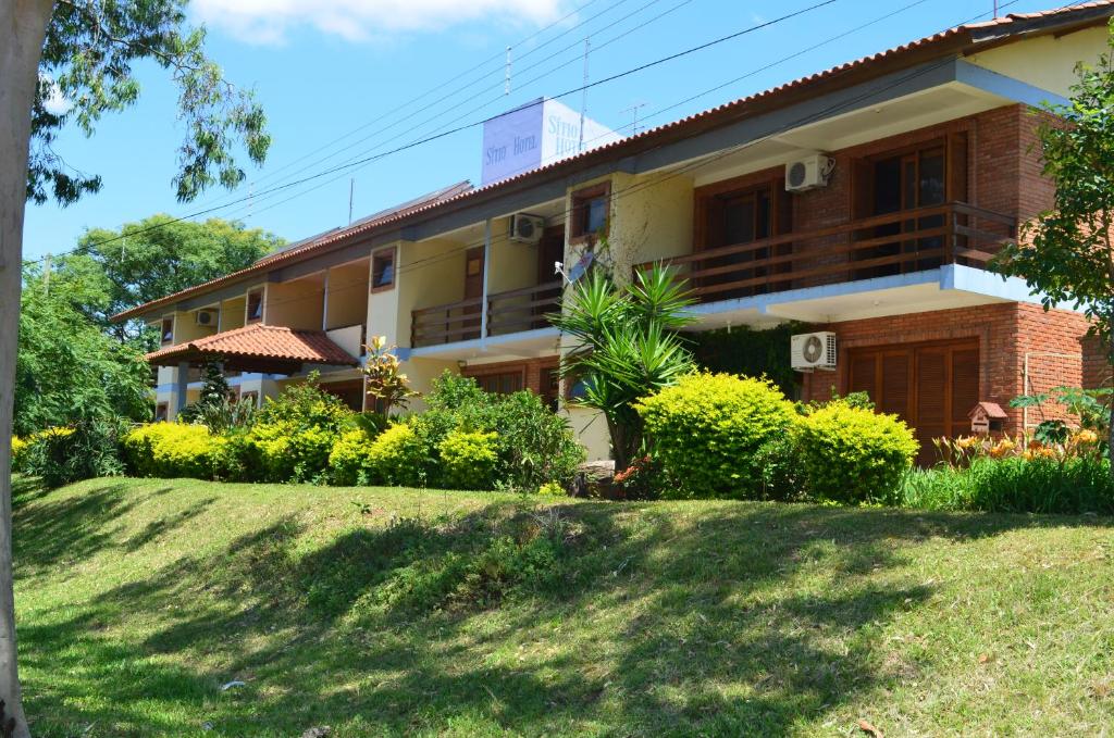 une maison avec une pelouse devant elle dans l'établissement Sítio Hotel e Eventos, à Sao Pedro do Sul