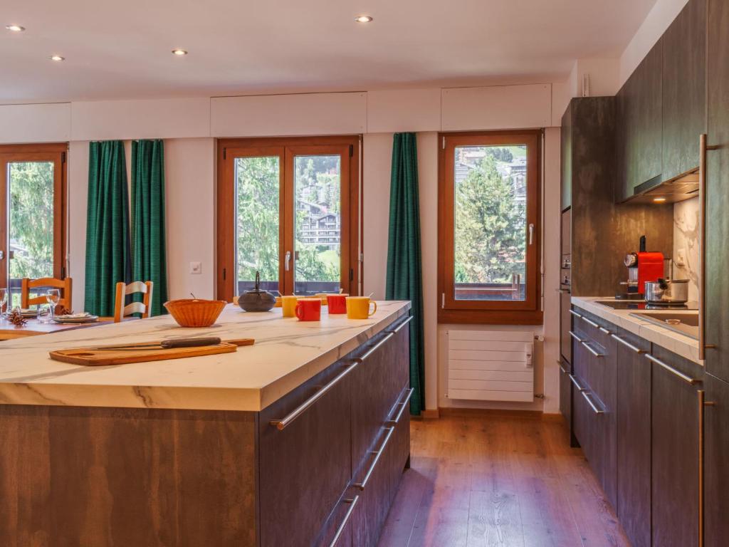 a large kitchen with wooden counters and wooden cabinets at Apartment Praplan 21-22 by Interhome in Nendaz