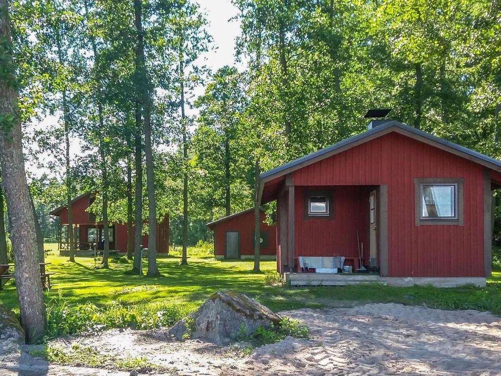a red cabin in the middle of a forest at Holiday Home Långstrands stuga by Interhome in Långstrand
