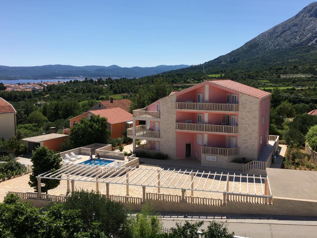 a building with a swimming pool and a resort at Apartments Villa Jennifer in Orebić