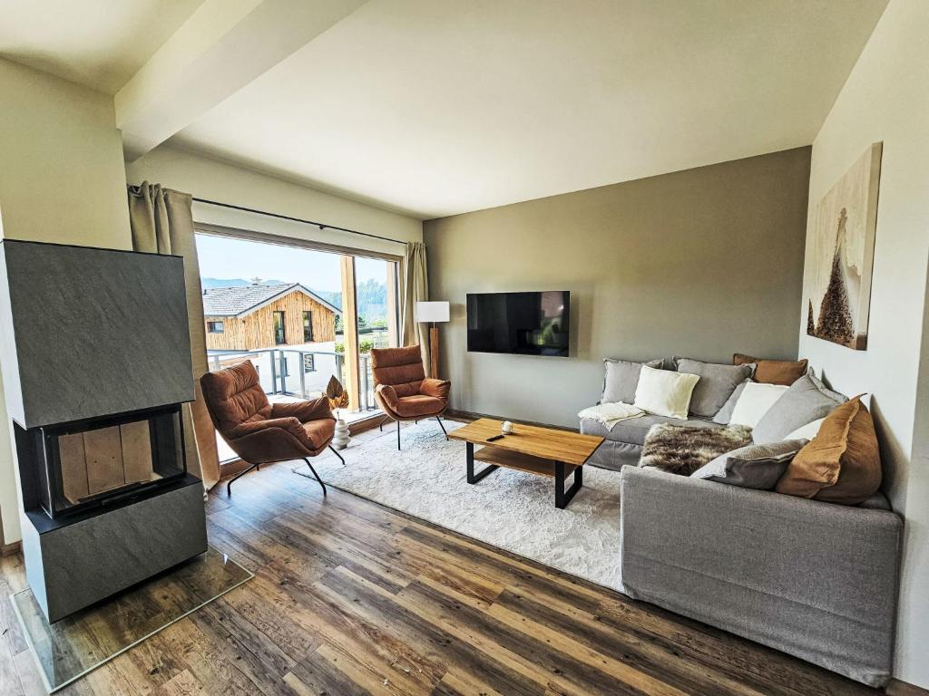 a living room with a couch and a fireplace at Chalet Ossiacher See Chalet 2 by Interhome in Bodensdorf