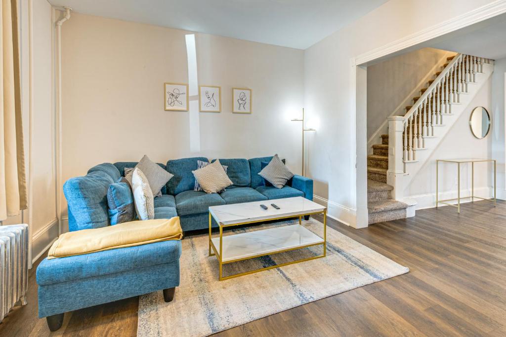 a living room with a blue couch and a table at Shop and Dine Central Stroudsburg Townhome! in Stroudsburg