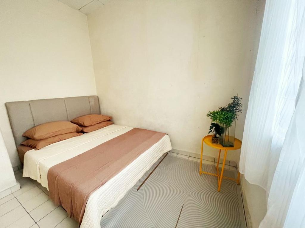 une petite chambre avec un lit et une table dans l'établissement TheMerits Homestay, à Ipoh