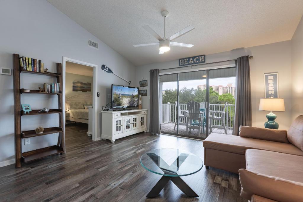 a living room with a couch and a glass table at Palmetto 306 in Orange Beach