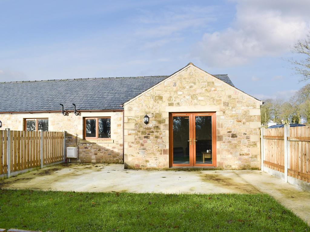 a stone house with a wooden fence in front of it at One Dorchester Drive - Uk32037 in Inglewhite