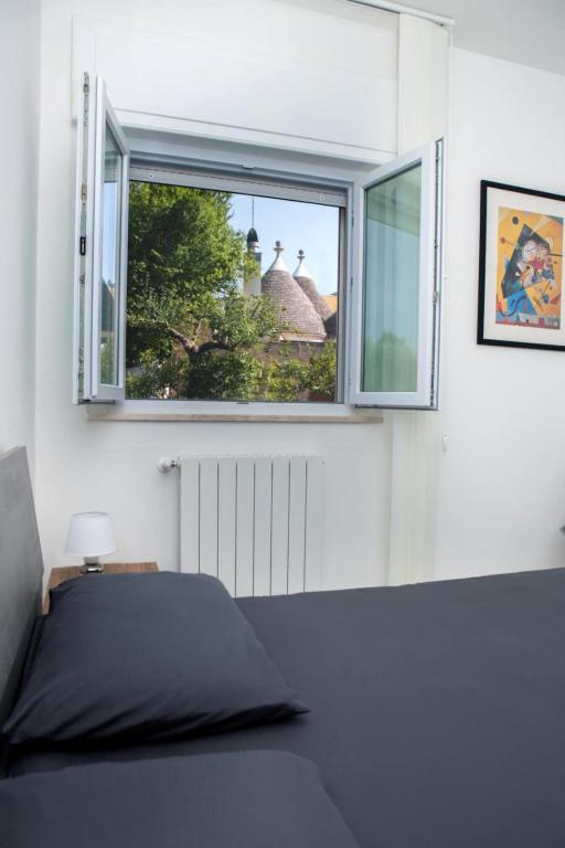 a window in a white room with a black bed at Perla D'Itria in Locorotondo