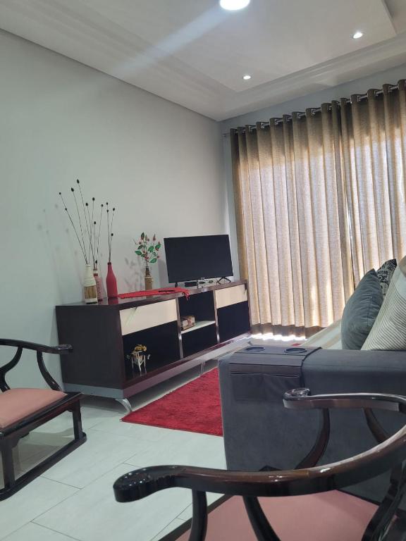 a living room with a couch and a tv at Sobrado na Cidade de Socorro in Socorro