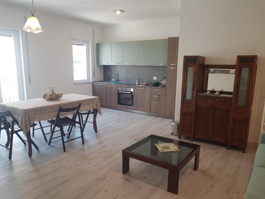 a living room with a table and a kitchen at CasaLisetta in Serracapriola