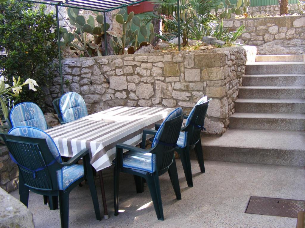 a table and chairs with a table and some stairs at Apartment Petra in Tribunj