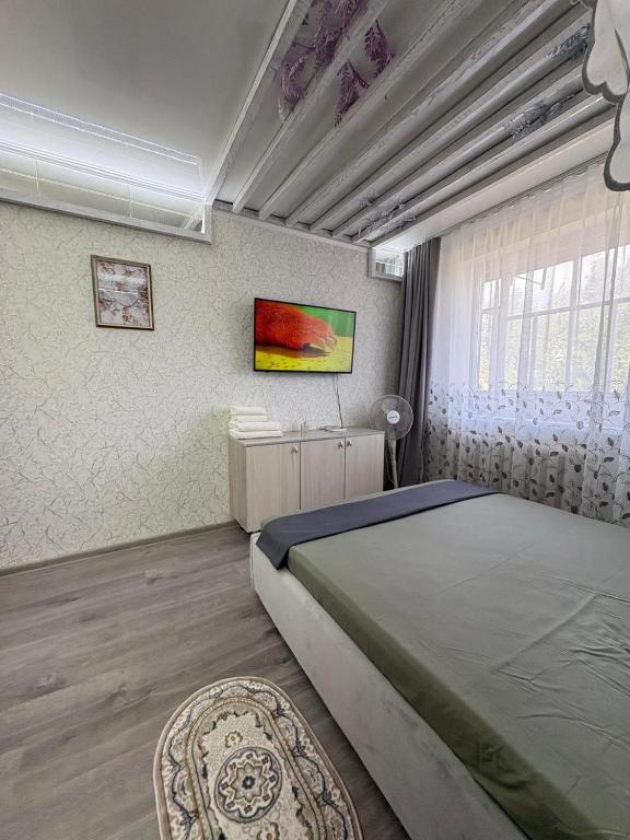Un dormitorio con una cama grande y una ventana. en Кривенко 85, en Pavlodar