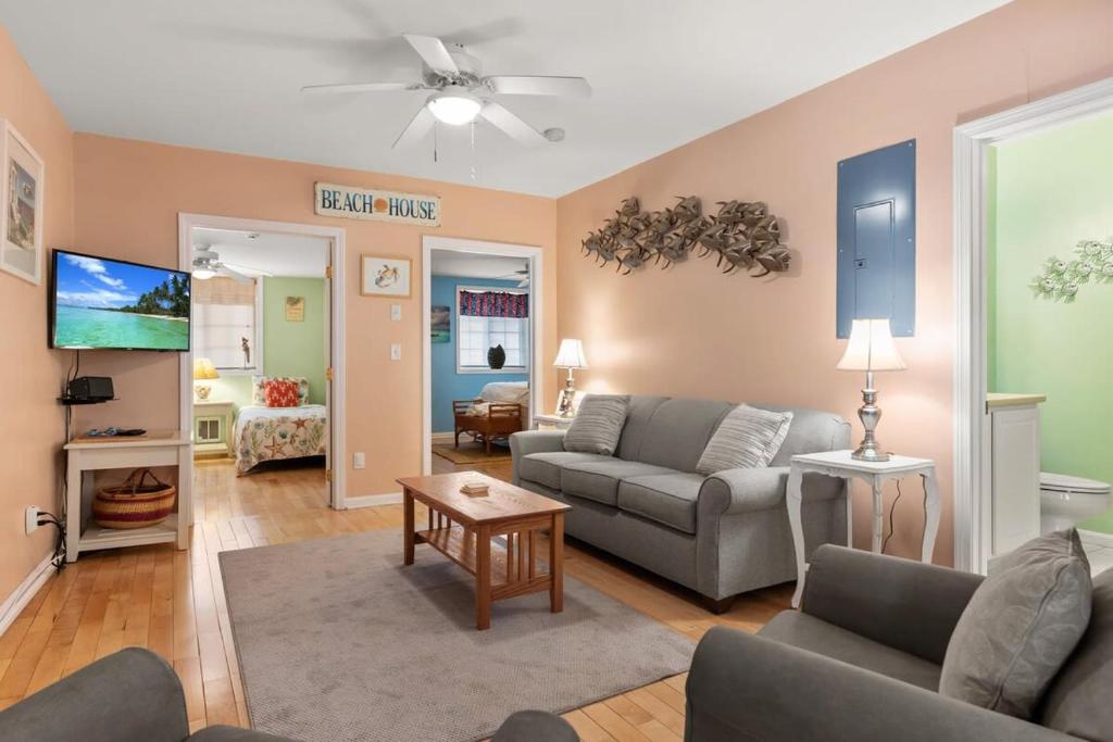 a living room with a couch and a tv at Stay Steps from Beach with Pool AC Parking in Hampton
