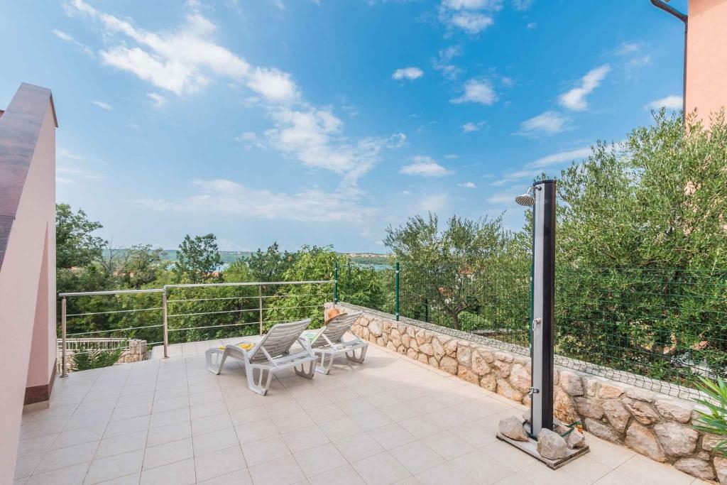a patio with two chairs sitting on top of a building at Apartments in Klimno - Insel Krk 13574 in Klimno