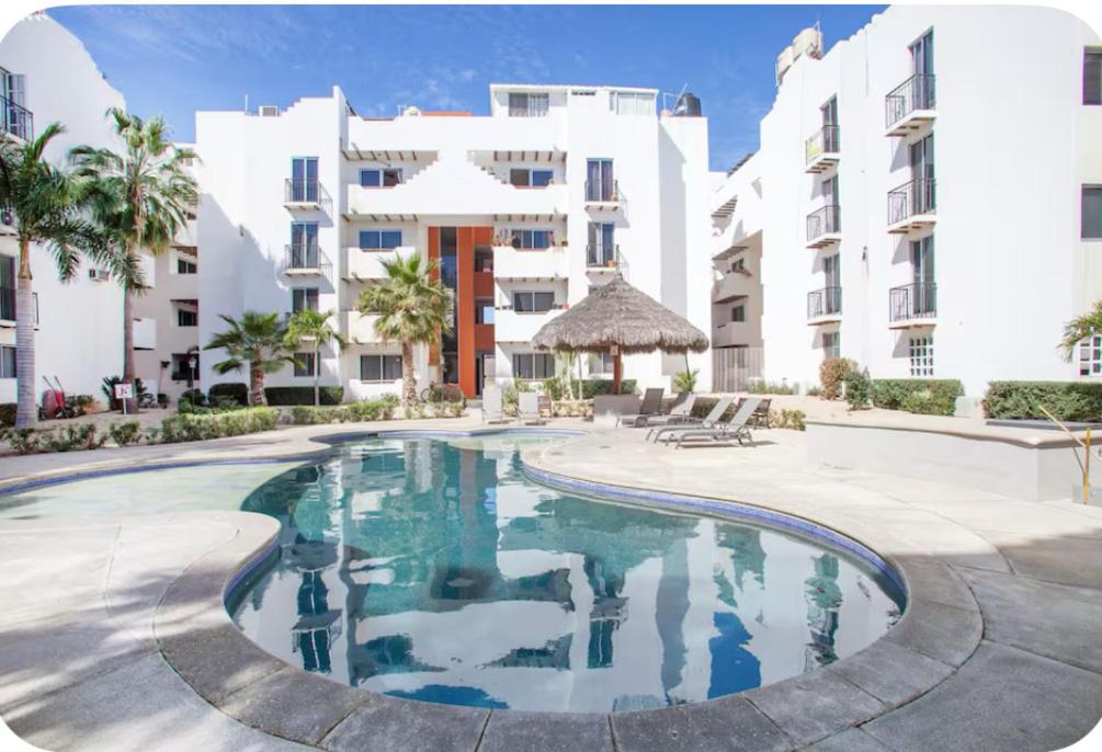 a swimming pool in front of a building at Cabo3Br Close to Medano Beach in Cabo San Lucas