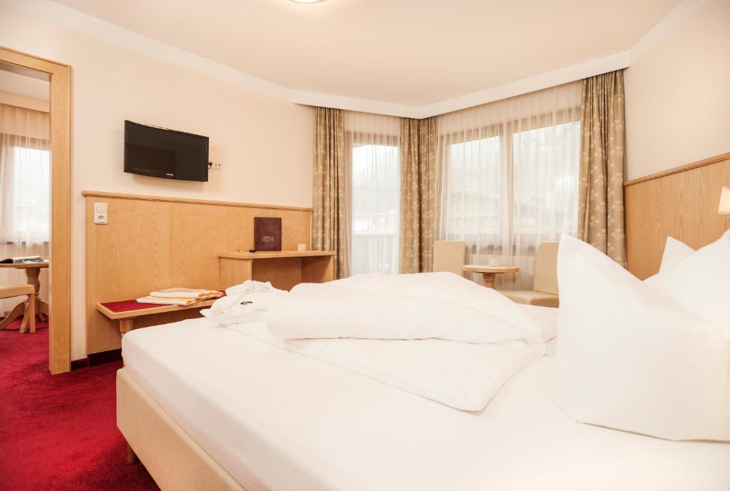 Postel nebo postele na pokoji v ubytování Hotel Alpenhof Kristall