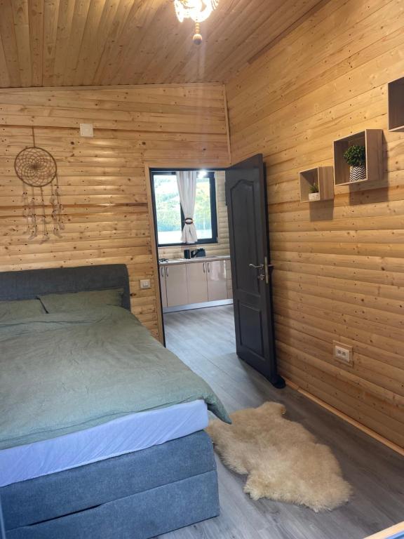 a bedroom with a bed in a wooden room at Maya Lake House Ponton Bicaz 