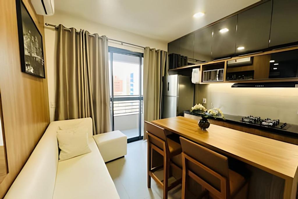 a kitchen with a couch and a table in a room at Loft exclusive a 200 metros da Ufu in Uberlândia