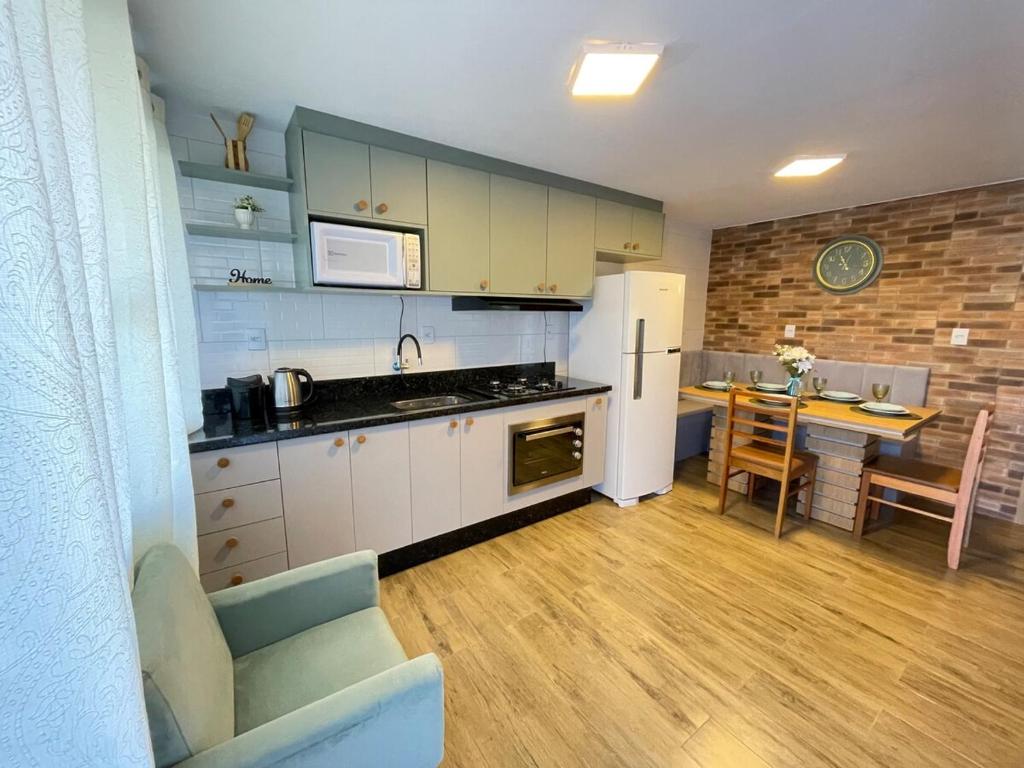 a kitchen with a white refrigerator and a table at Casa em Penha- SC in Penha