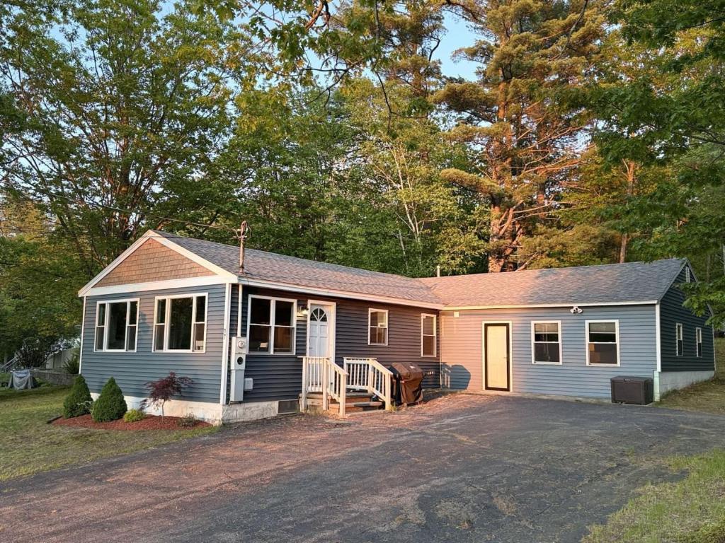 a small blue and white house with a driveway at Central Location 4BR w Boat Slip Option in Gilford