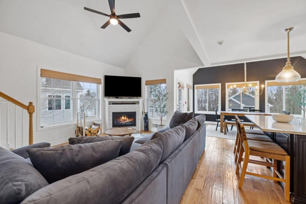 sala de estar con sofá, mesa y chimenea en The Weirs Retreat - Lake Getaway with Pool Access, en Laconia