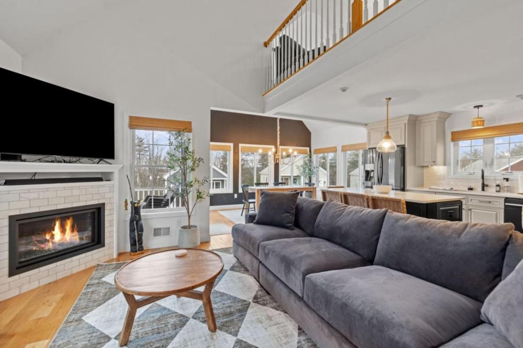 a living room with a couch and a fireplace at Modern Winnipesaukee Retreat, Pool & Deck, Weirs in Laconia