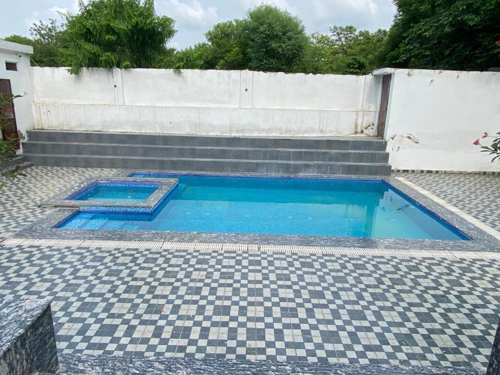 une piscine sur un sol carrelé avec un mur dans l'établissement Hotel valley View, à Jaipur