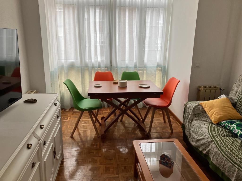 a small table with four chairs in a room at El COTO - VUT 6639 AS in Gijón