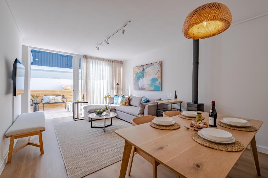 a living room with a table and a couch at Chic Coastal Hideaway in Hermanus