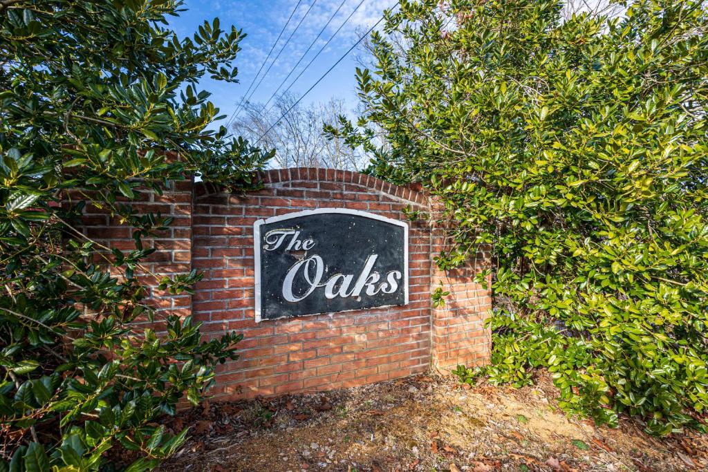 a sign that says the oaks on a brick wall at HIckernut Lodge by American Patriot Getaways in Walnut Grove