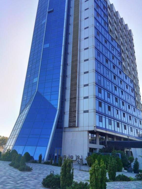 a tall blue building with trees in front of it at Studio Olimp Sea View Apartments in Olimp