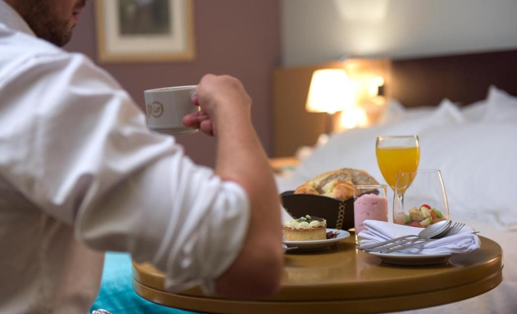 een man die een foto neemt van een tafel met eten en drinken bij Hotel y Casino Del Río - Cipolletti in Cipolletti