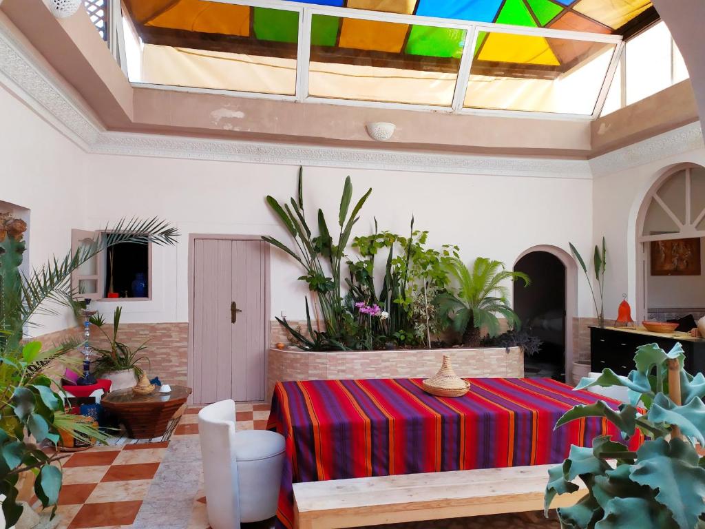 a living room with a table with a multicolored blanket at Riad N'tayri - Séjour intimiste et authentique - Accueil personnalisé in Tamraght Ouzdar