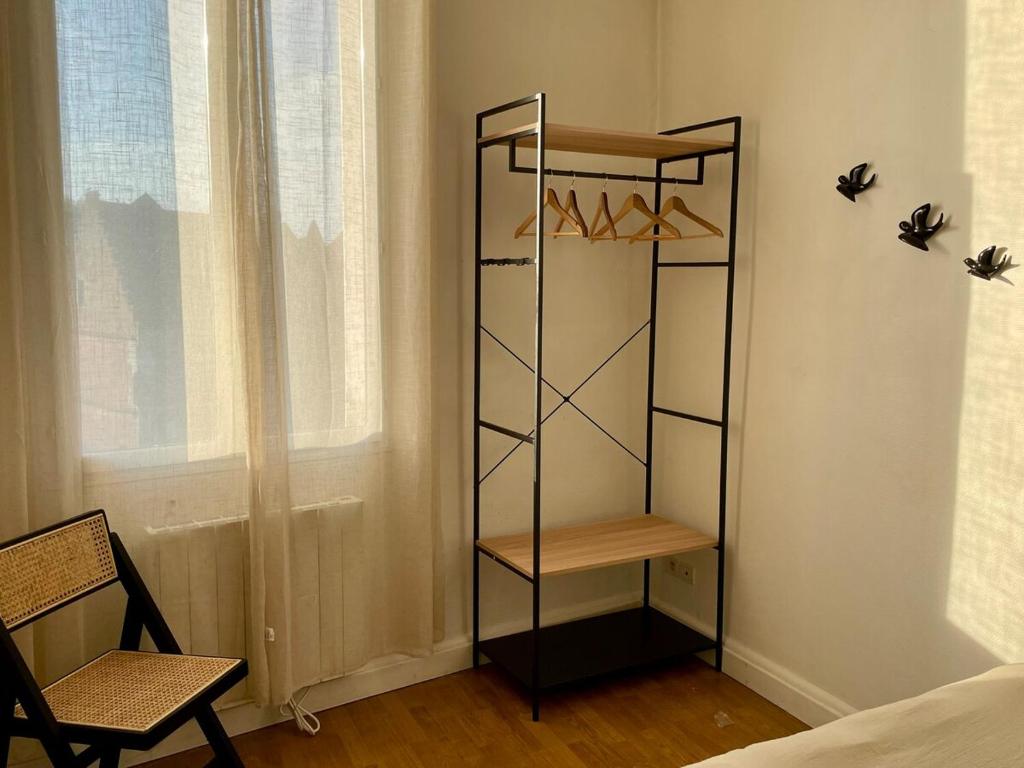 a shelf in a room next to a window at L'escapade de saint Antoine in Compiègne