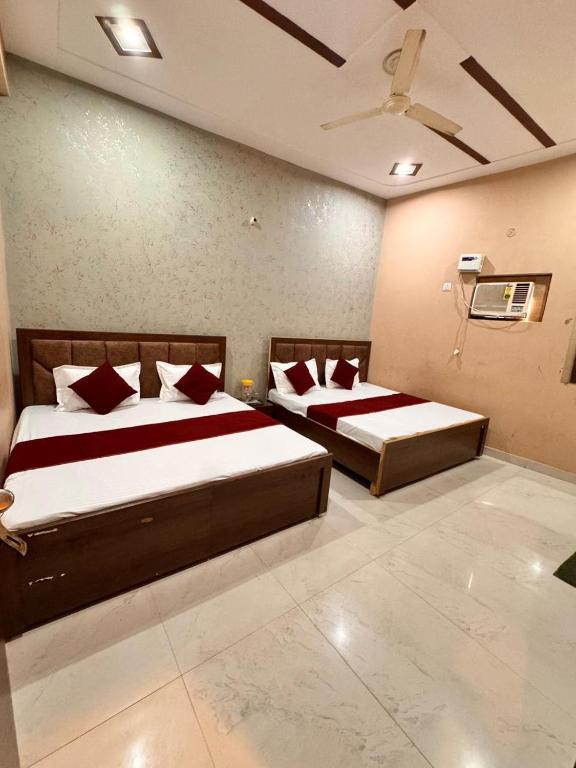 um quarto com duas camas e um ventilador de teto em Raghav dham em Vrindāvan