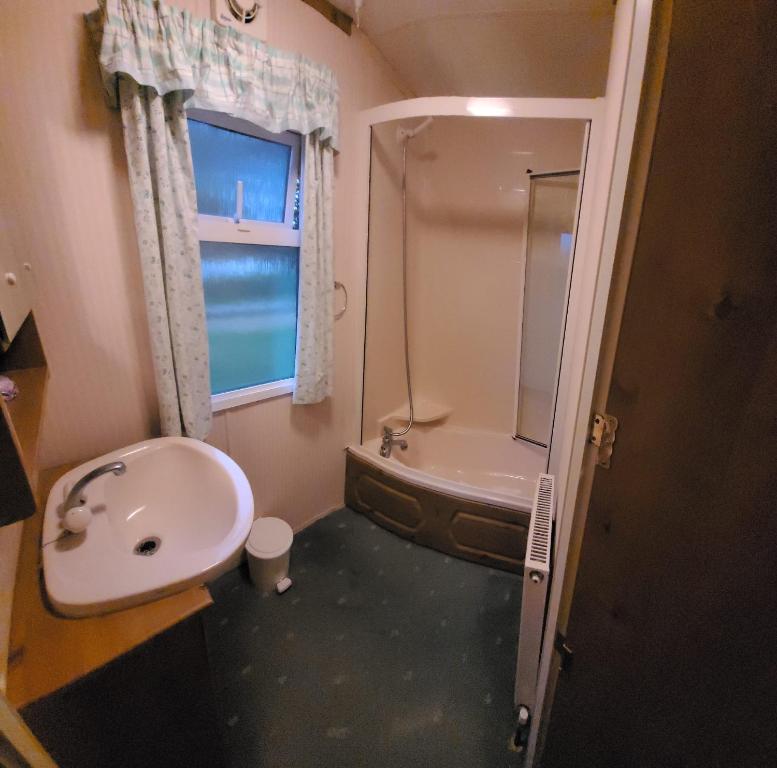 a small bathroom with a sink and a shower at Domek Leśny in Czarny Młyn
