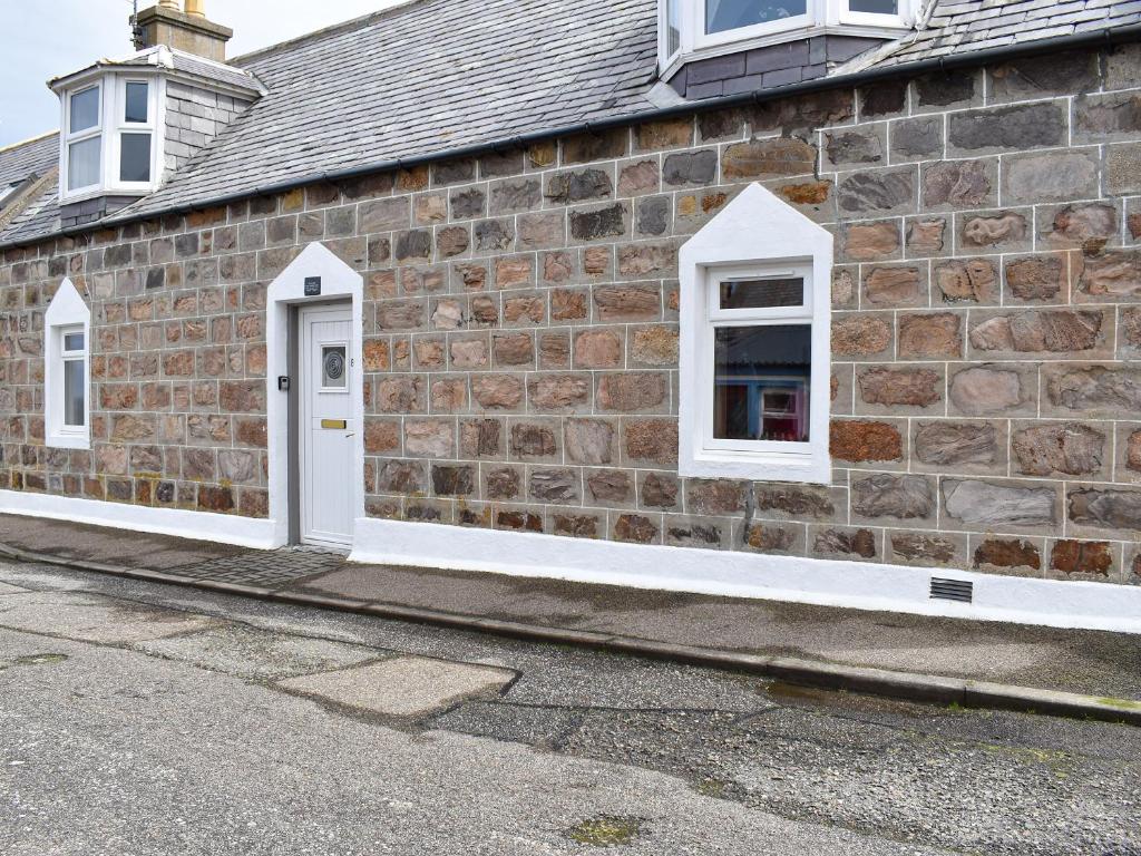 a brick building with white doors and windows at Tradewinds in Portknockie