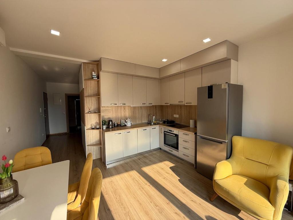 Il comprend une cuisine équipée d'un réfrigérateur, d'une table et de chaises. dans l'établissement Spacious 2 bedroom Apartment near Marina by Solea Homes, à Tivat