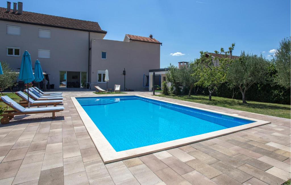 a swimming pool in a yard next to a house at Awesome Home In Imotski in Imotski