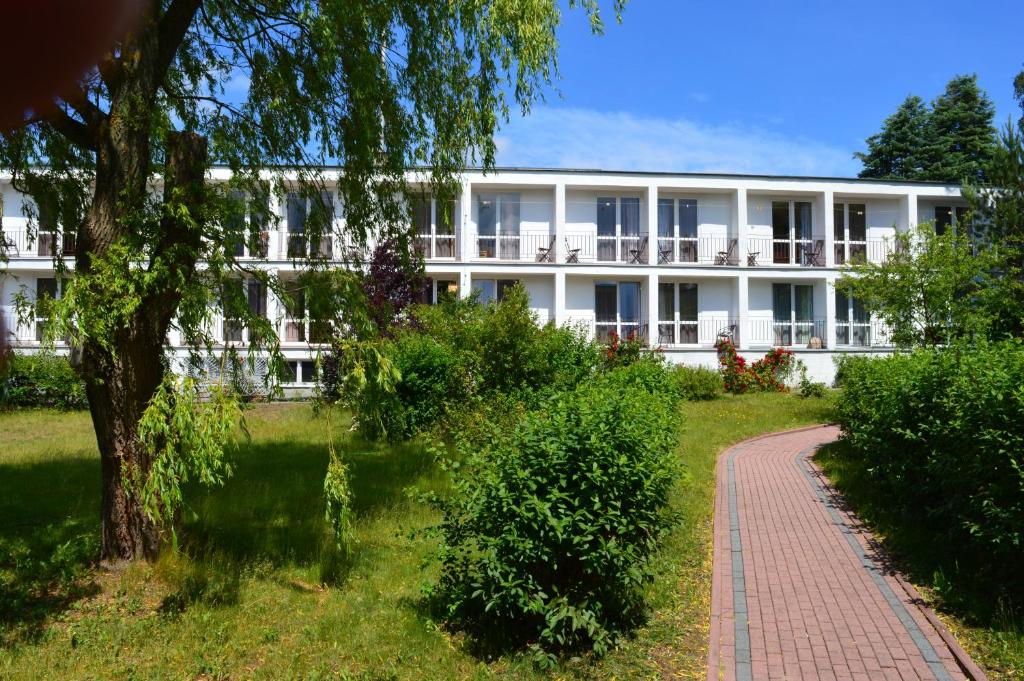 un bâtiment blanc avec un chemin en briques devant lui dans l'établissement OW Żeglarz, à Jastrzębia Góra