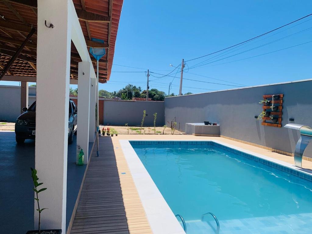 a large swimming pool in a house with a car at Casa Portal da Lagoinha in Tigre