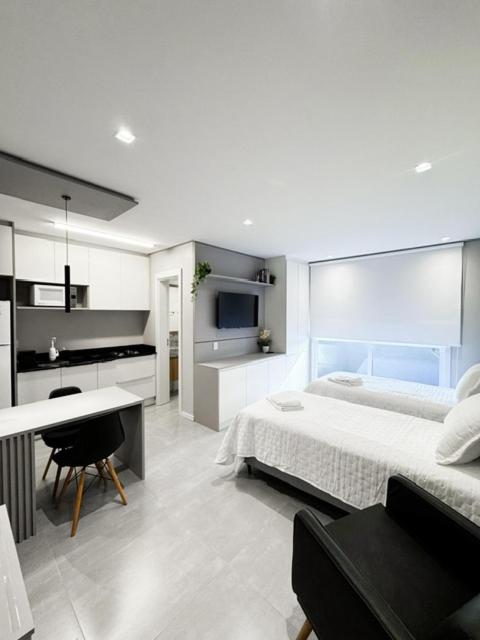 a bedroom with a bed and a desk in it at Loft H1273 Apto 502 in Caxias do Sul
