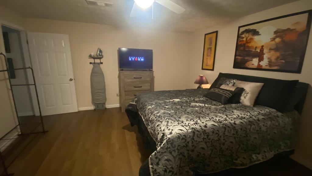 a bedroom with a bed and a flat screen tv at Your Private 1-Bedroom Guest House in College Park in College Park