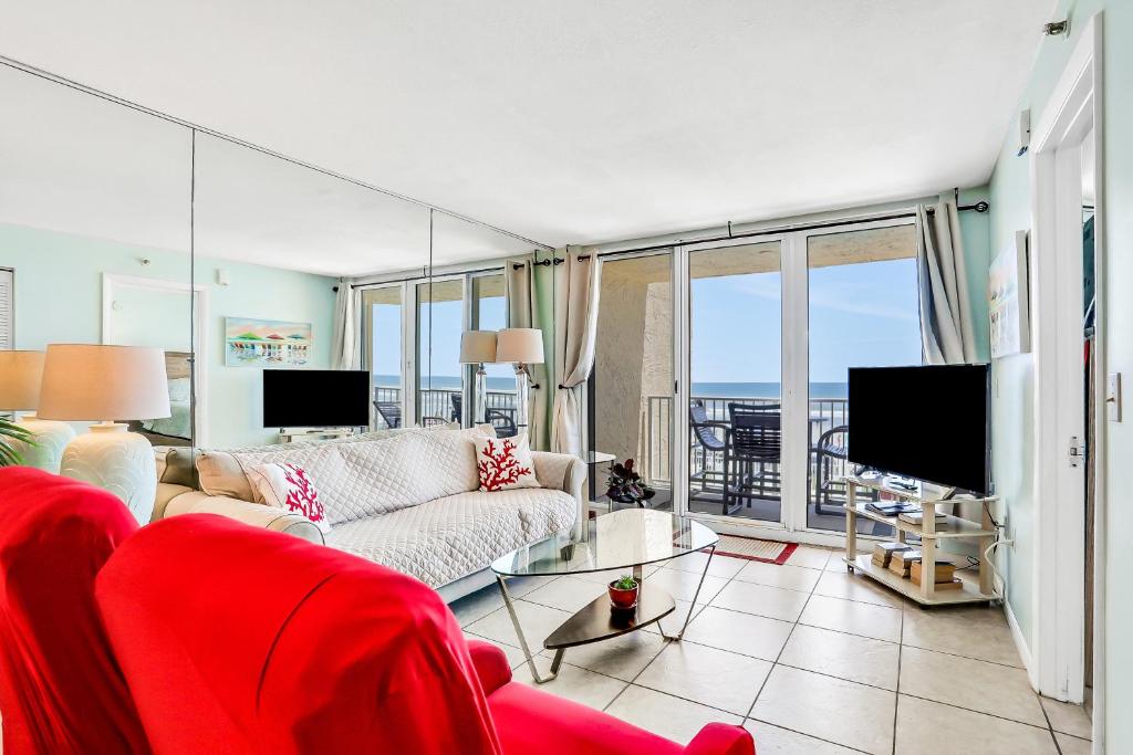 Una sala de estar con un sofá y vista al mar. en Oceania Plaza 204, en New Smyrna Beach