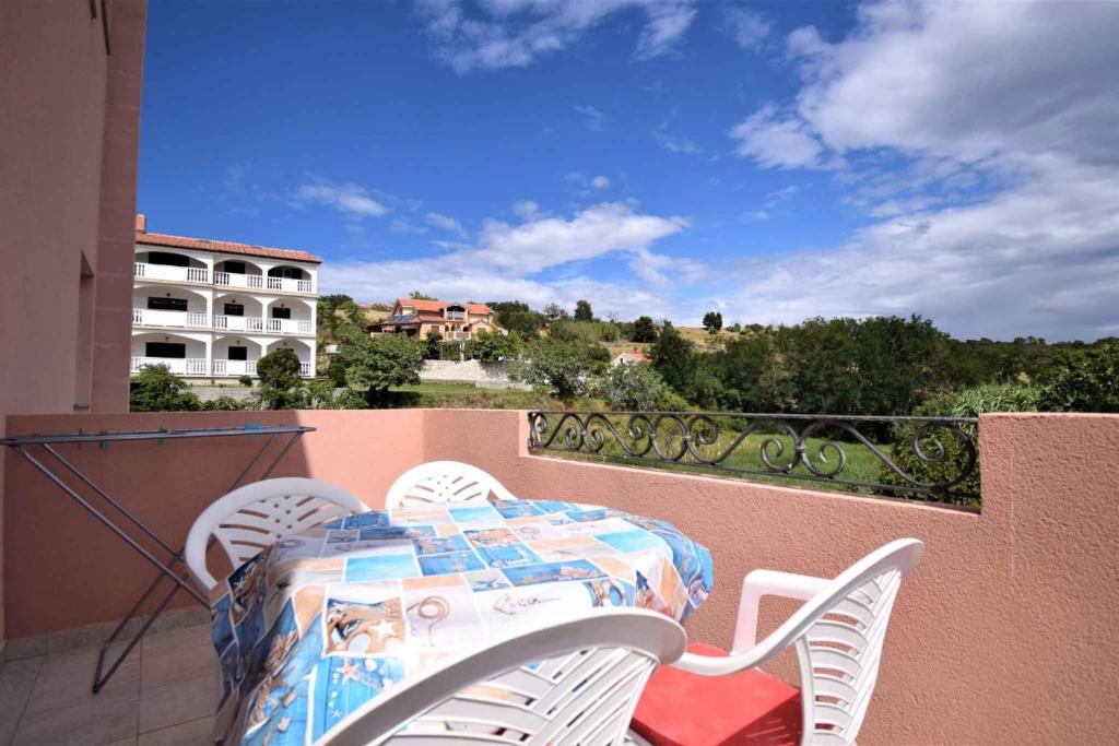 a table and chairs sitting on a balcony at Apartment in Lopar in Lopar