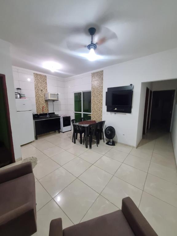a living room with a table and a ceiling fan at Casa Atenas 2 in Três Lagoas