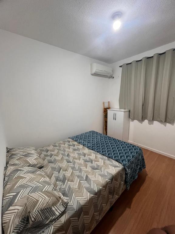 a bedroom with a bed in a room with a window at Ap em ótima localização in Cuiabá