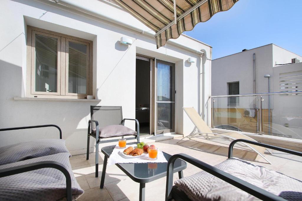 a balcony with a table with fruit on it at Isma Luxury Stay in Oristano