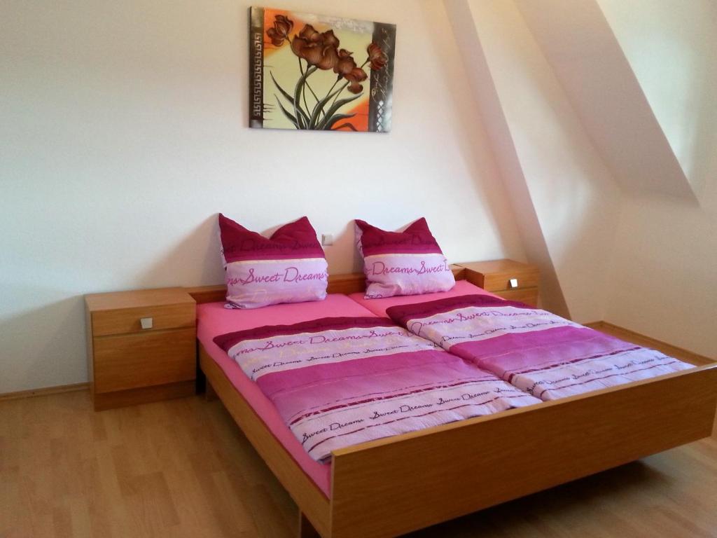 1 dormitorio con cama con sábanas rosas y almohadas rosas en Ferienwohnung Ernesto, en Rust