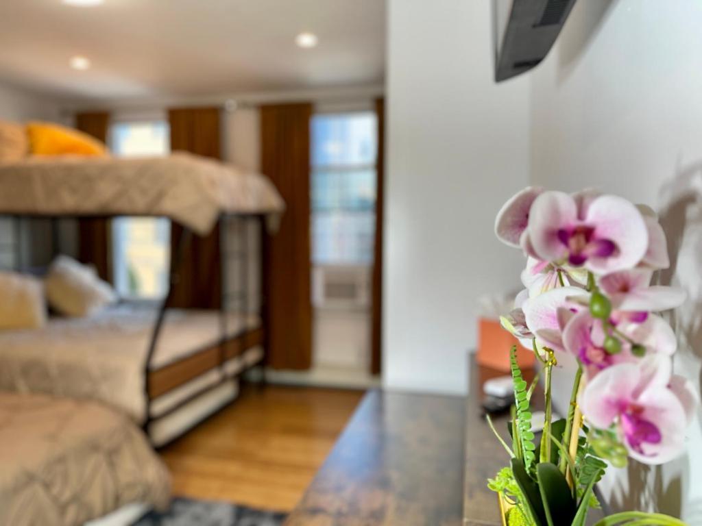 a vase with flowers on a table in a living room at BP STAYS - Hotel-Style, No Host, Professionally Managed ID260 in Jersey City